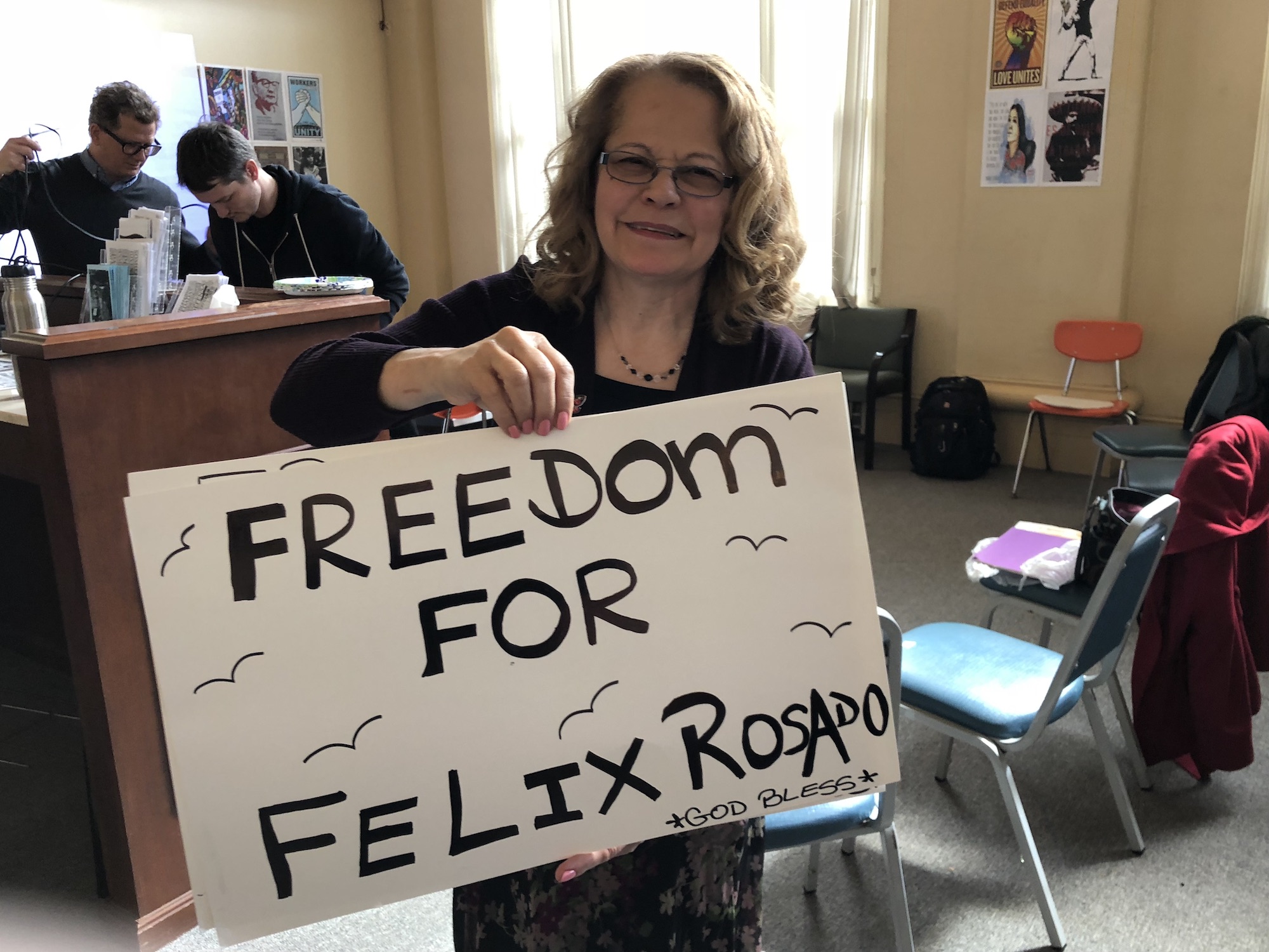 Iris Drey holds a sign that says 'Freedom for Felix Rosado' at a community meeting in Reading, PA