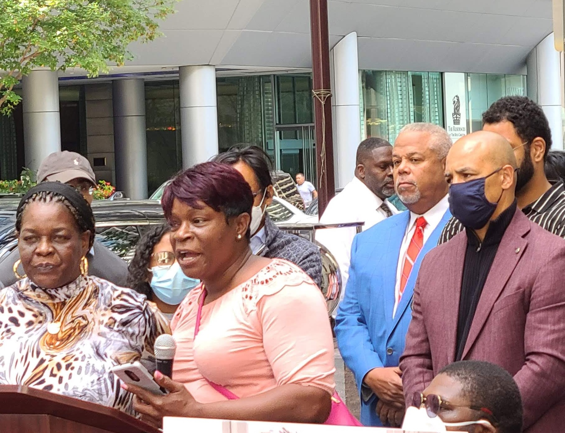 Martha holds a microphone as she speaks at a rally