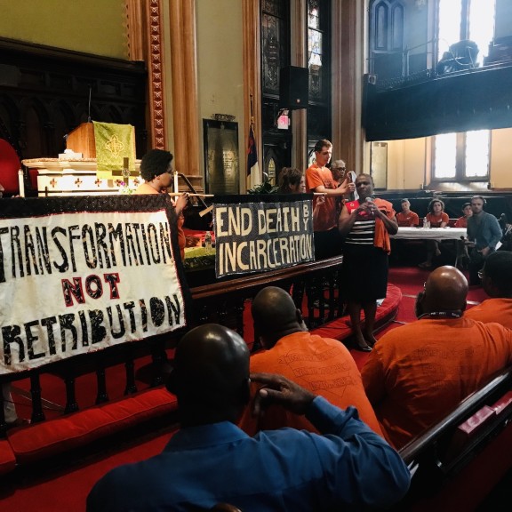 People gather in a church for the community resentencing in support of Kempis Songster