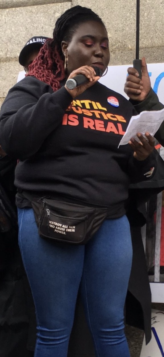 Nikki Grant holds a mic at a protest