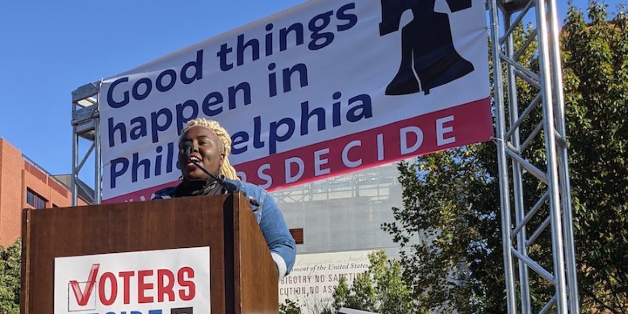 Nikki Grant stands at the podium at the Voters Decide rally