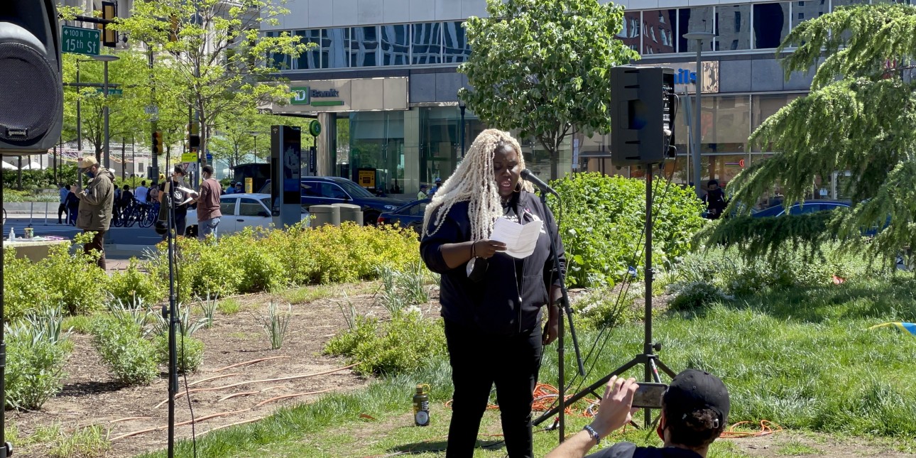 Nikki Grant stands at Love Park and speaks into a microphone