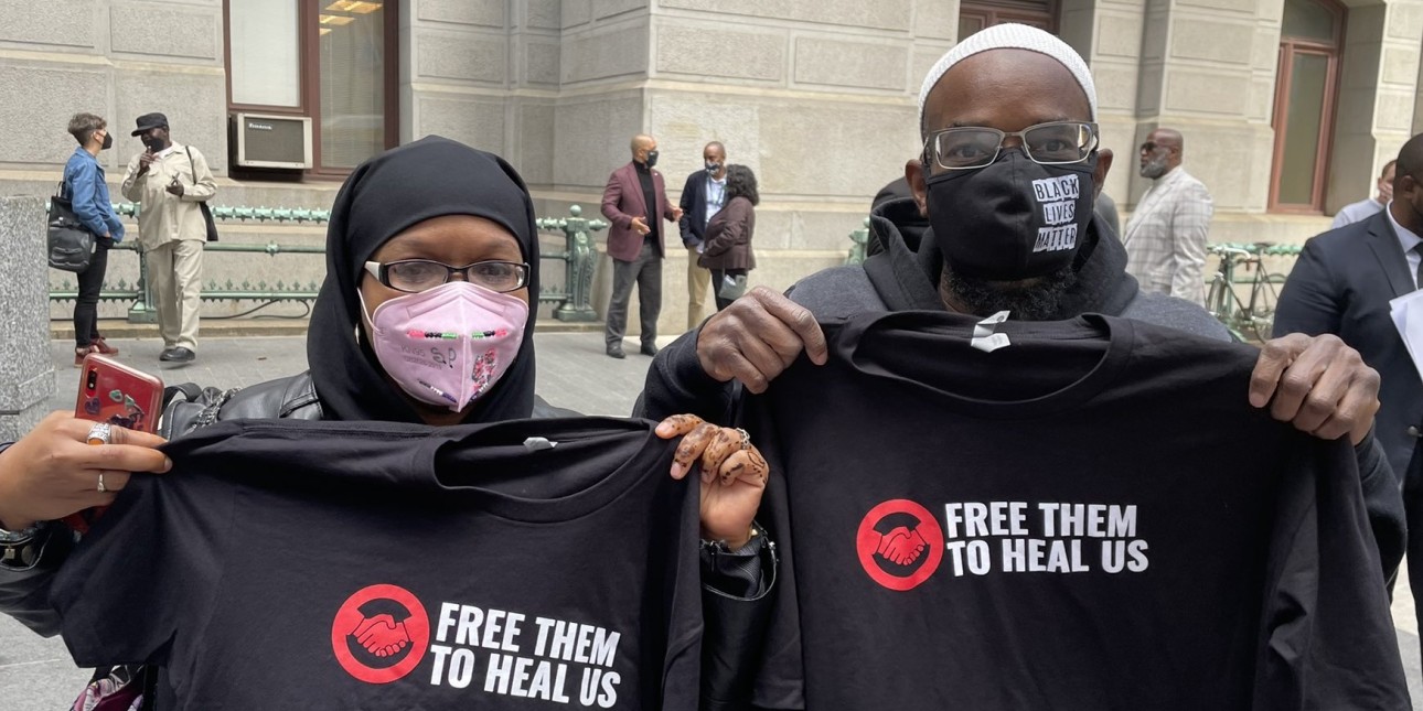 Shamar and Shymita two members of Free Them to Heal Us hold up t-shirts at a rally for geriatric parole