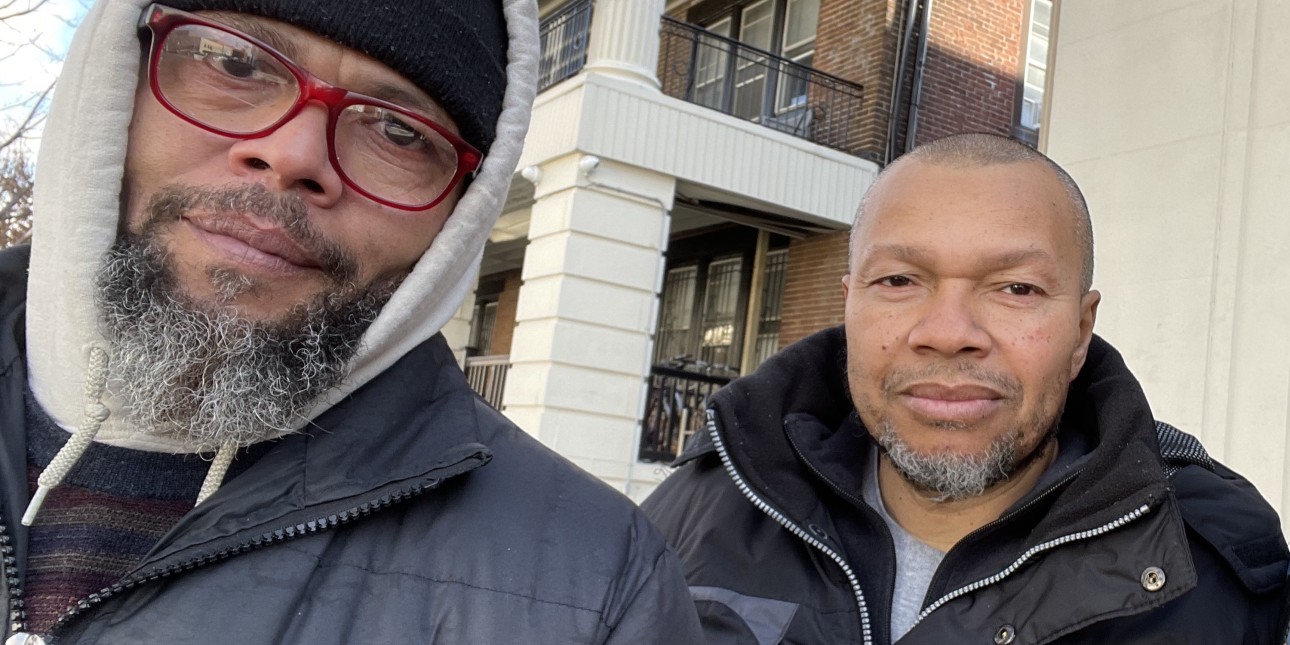 Reid and Wyatt Evans look into the camera with an apartment building in the background