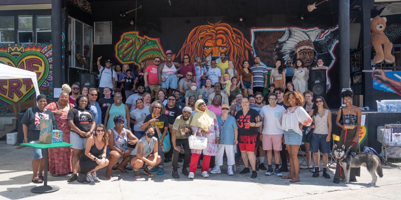 a large group of people pose for a photo in front of a stage