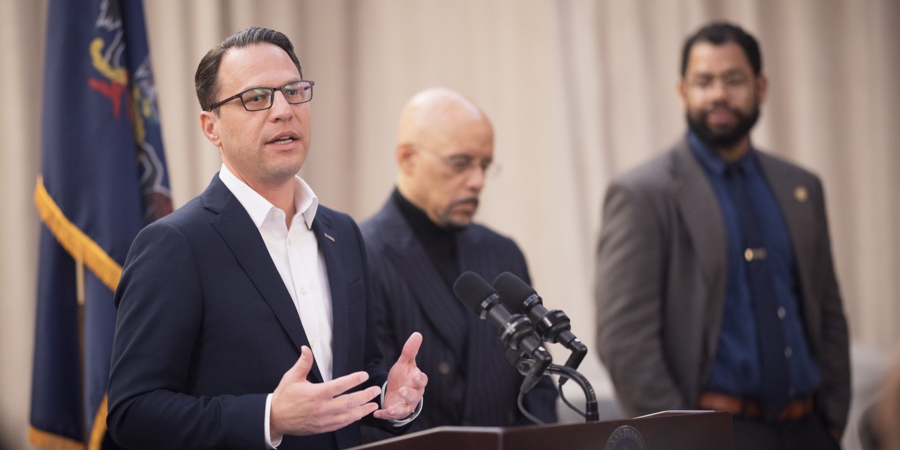 Josh Shapiro speaks to a crowd with Senator Vincent Hughes and Rep. Rick Krajewksi in the background