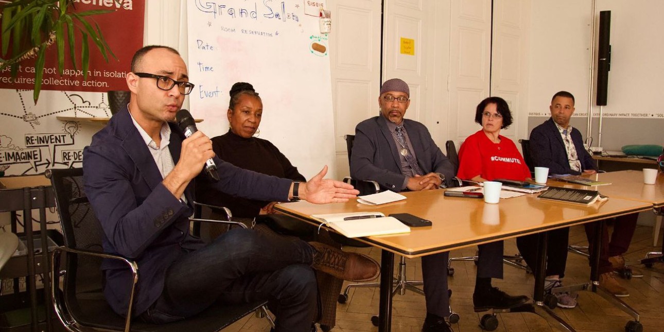 Saleem Holbrook holds the microphone on a panel d