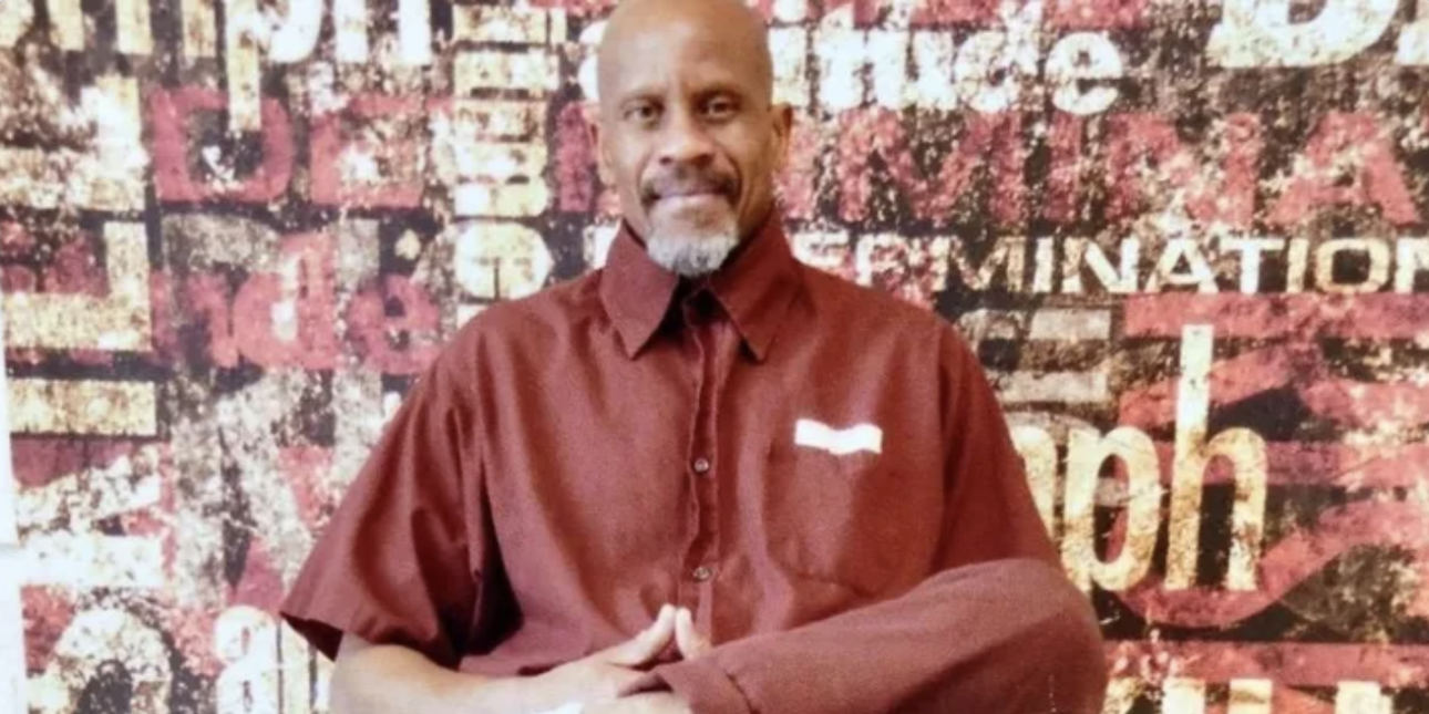 David "Dawud" Lee sits in front of a poster 