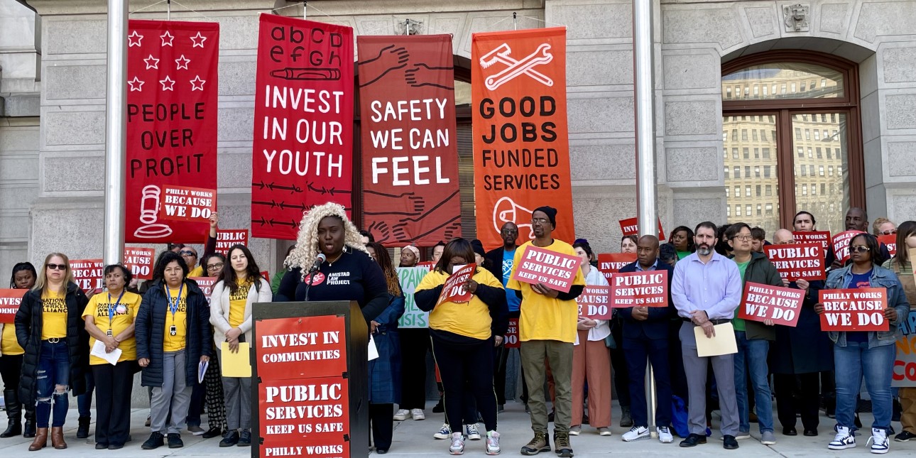 Nikki Grant speaks at a podium alongside community organizations calling for a Philly budget prioritizes working people