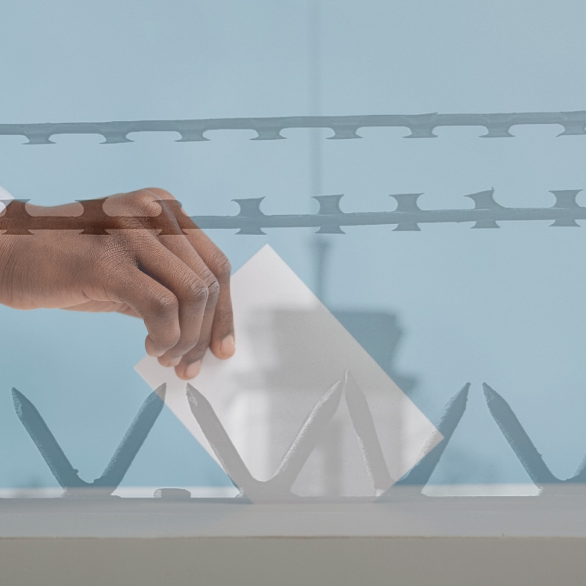 image shows a hand putting a ballot into a ballot box juxtaposed over a transparent image of spikes on prison wall and razor wire