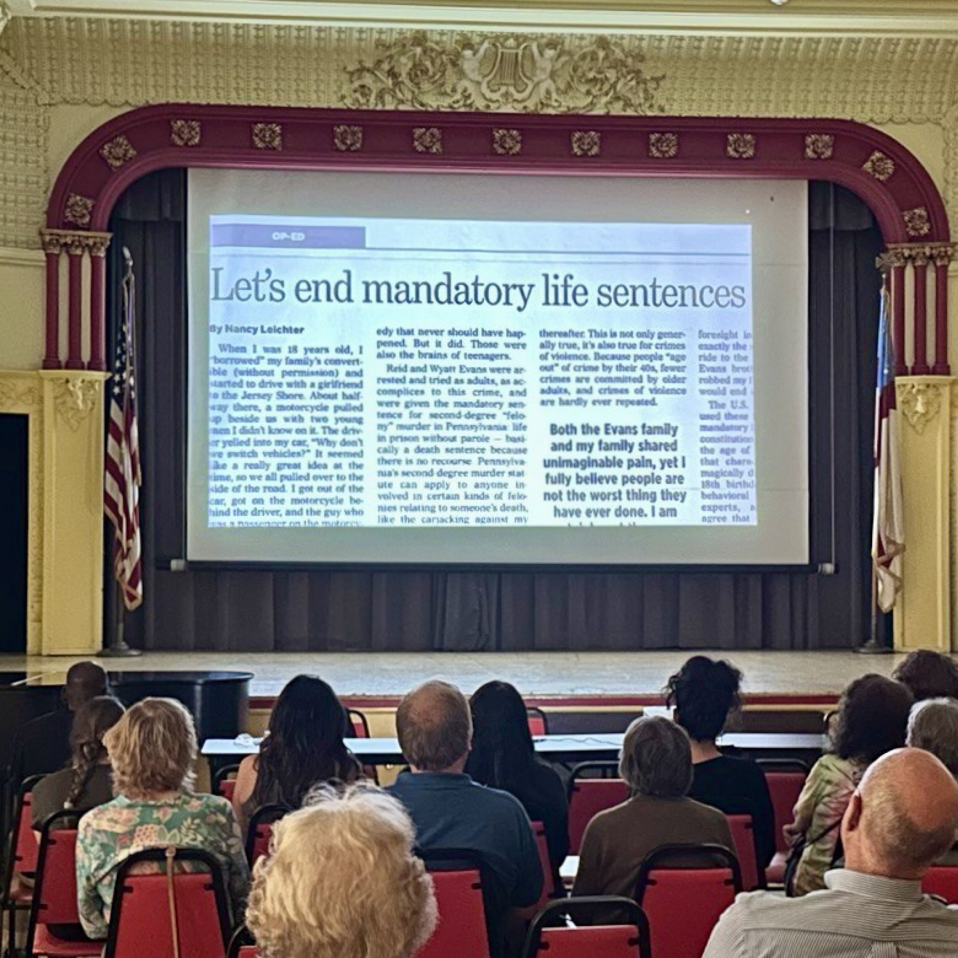 Audience watches documentary with a newspaper headline that says Let's end mandatory life sentences