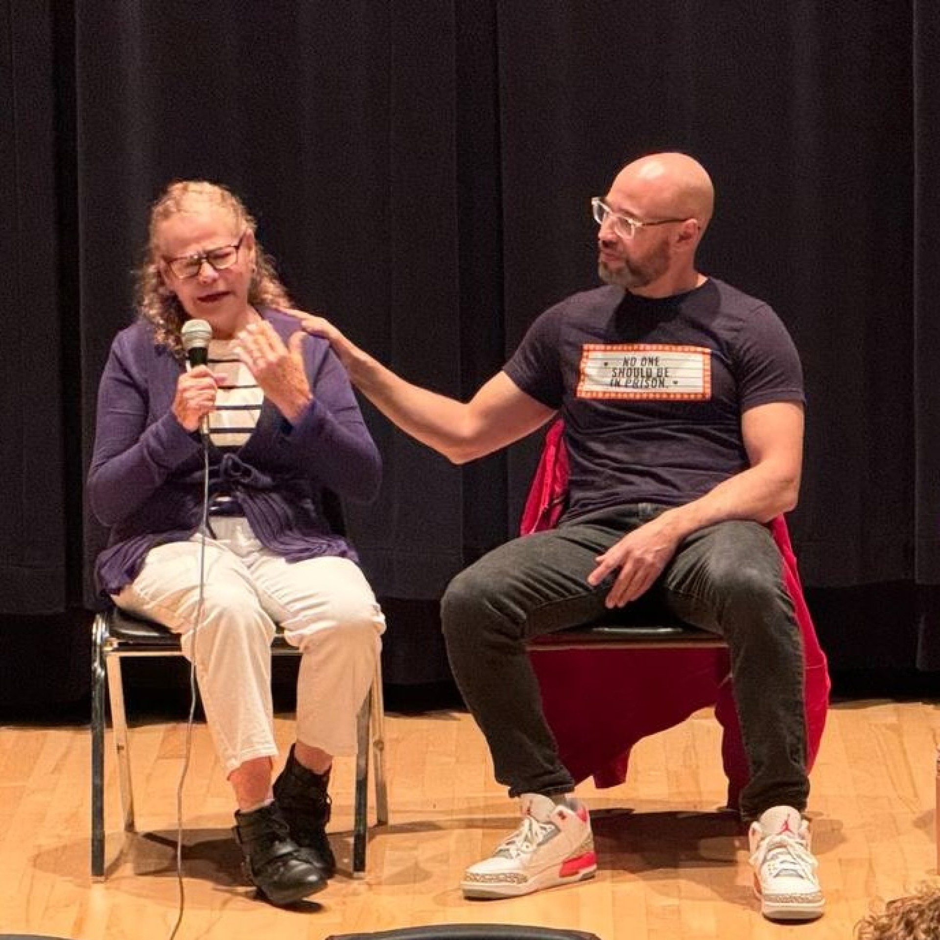 Felix Rosado comforts his mother Iris Drey as they speak on a panel in Reading, PA