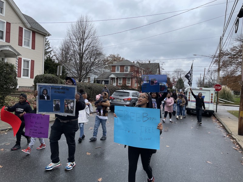 an image shows members of Angelo Strand's family marching with signs saying 'Free Big Yo' 