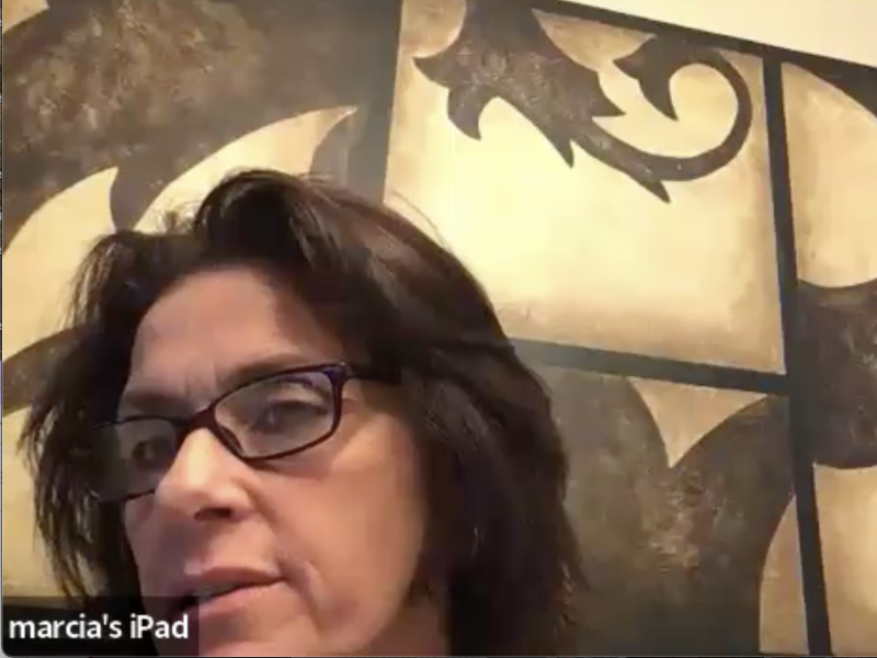 Marcie Marra looks at the camera with a brown and gold painting in the background
