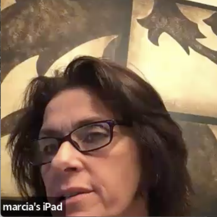 Marcie Marra looks at the camera with a brown and gold painting in the background